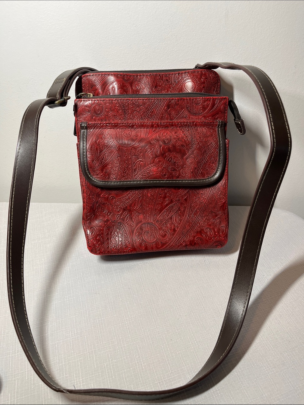 Relic Red Embossed Crossbody Messenger Bag with Brown Strap
Small 
Many pockets
